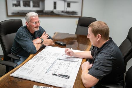 Jason Jackson reviewing remodeling plans at a desk with a customer
